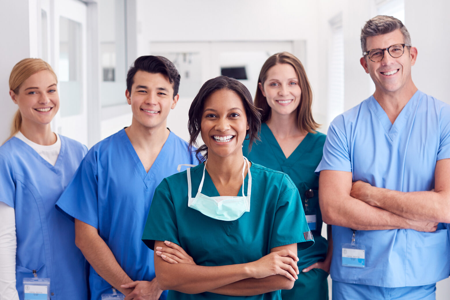 Portrait Of Smiling Multi-Cultural Medical Team Standing In Hospital Corridor